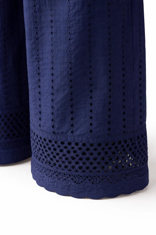 Close-up of navy blue eyelet embroidered pants with scalloped hem and lace details