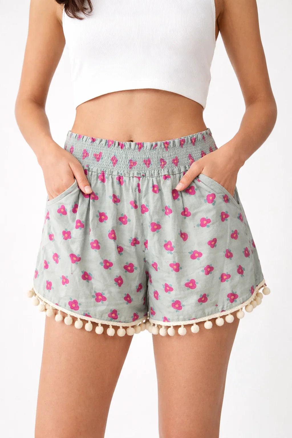 Women's grey floral shorts with pink flower print, pom pom trim, and smocked waistband