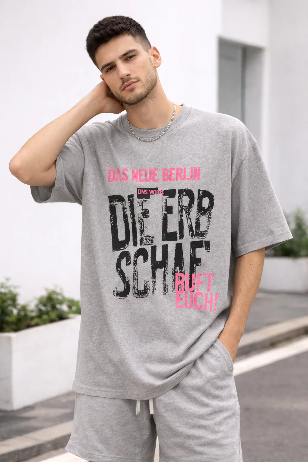 Man in casual grey shorts set with bold Berlin graphic text t-shirt outdoors