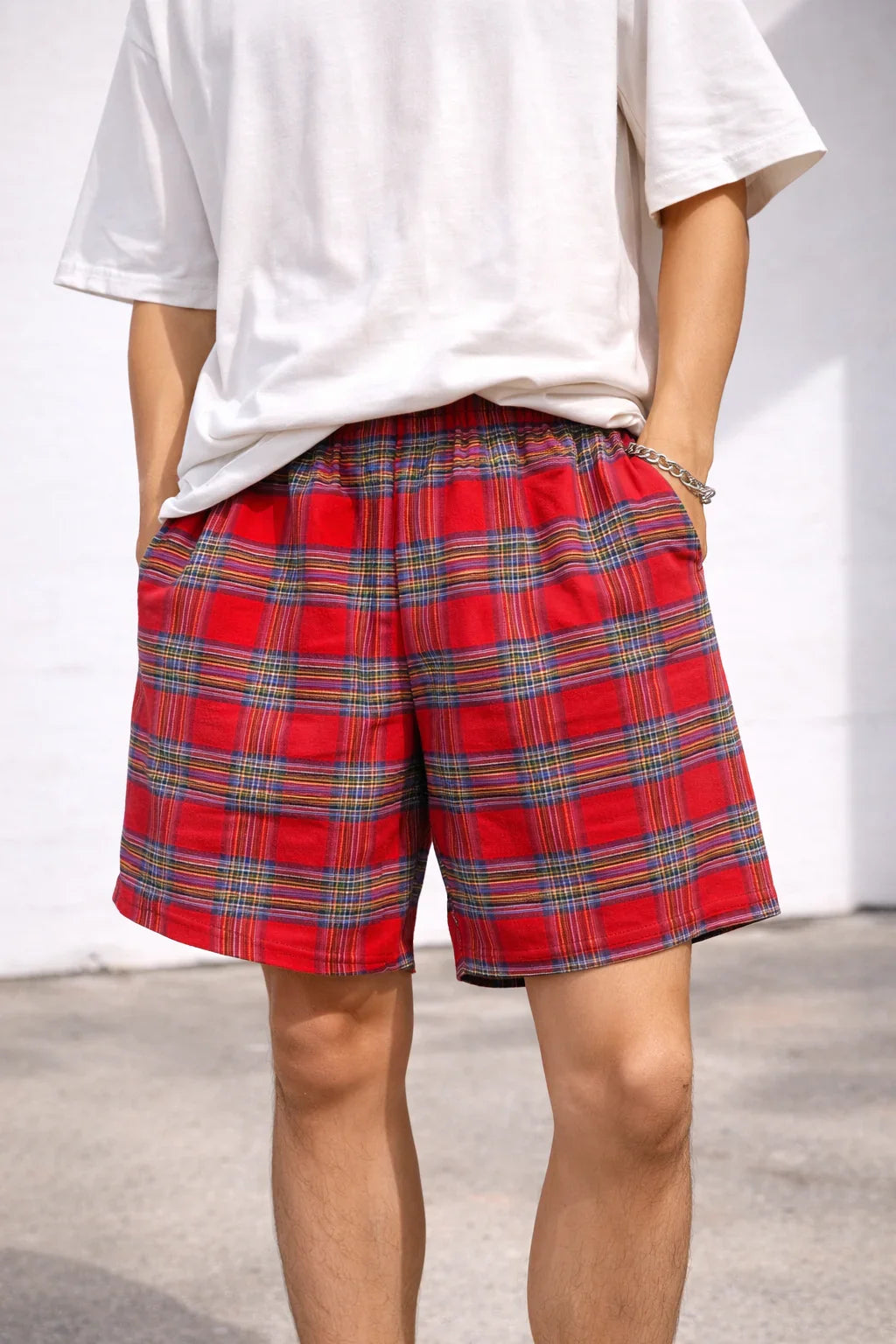 Red plaid cotton shorts with elastic waistband, worn with a white t-shirt outdoors