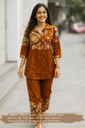 Woman wearing a brown floral coord set with buttoned top and matching pants, outdoor scene