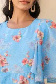 Woman wearing a blue floral dress with flutter sleeves and statement earrings