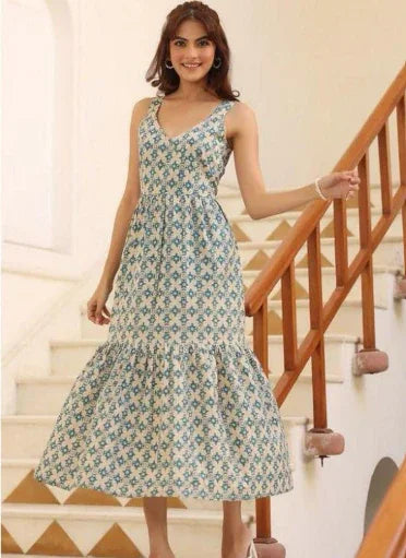 Woman wearing a sleeveless floral print maxi dress standing on indoor stairs