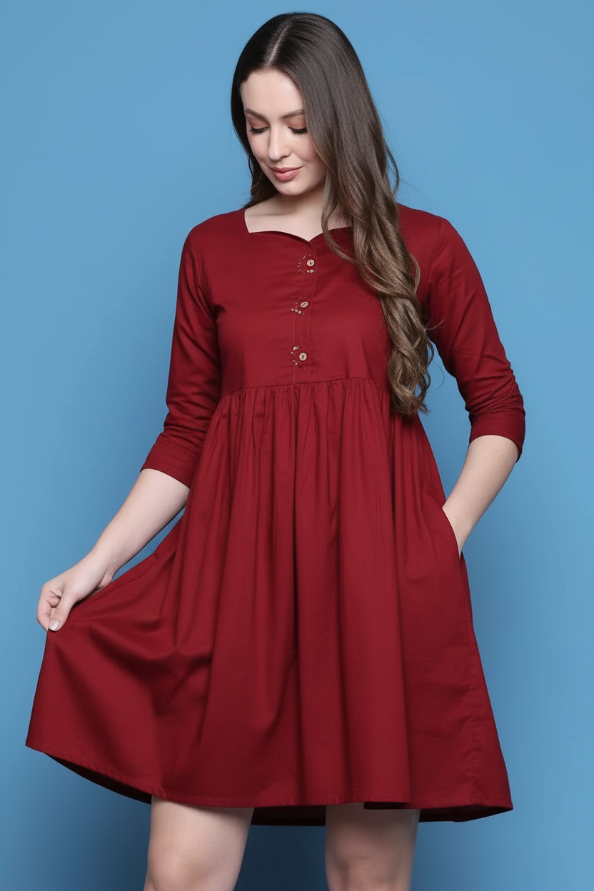 Model touching fabric of maroon dress - showing soft quality and side pockets