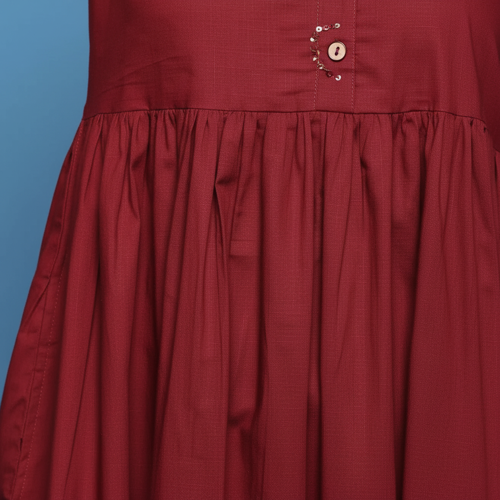Close-up detail of maroon dress gathered waist and fabric texture